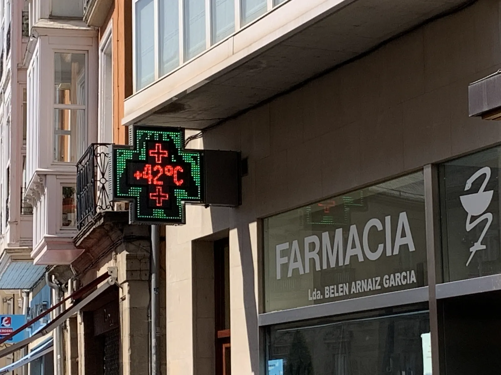 La cruz luminosa de una farmacia marca +42 ºC en una calle a pleno sol