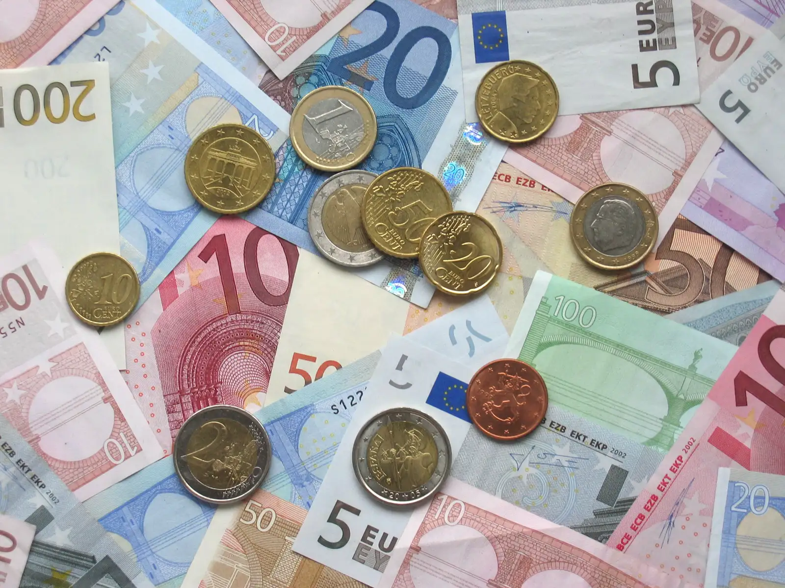 Billetes de euro de varios valores con monedas encima