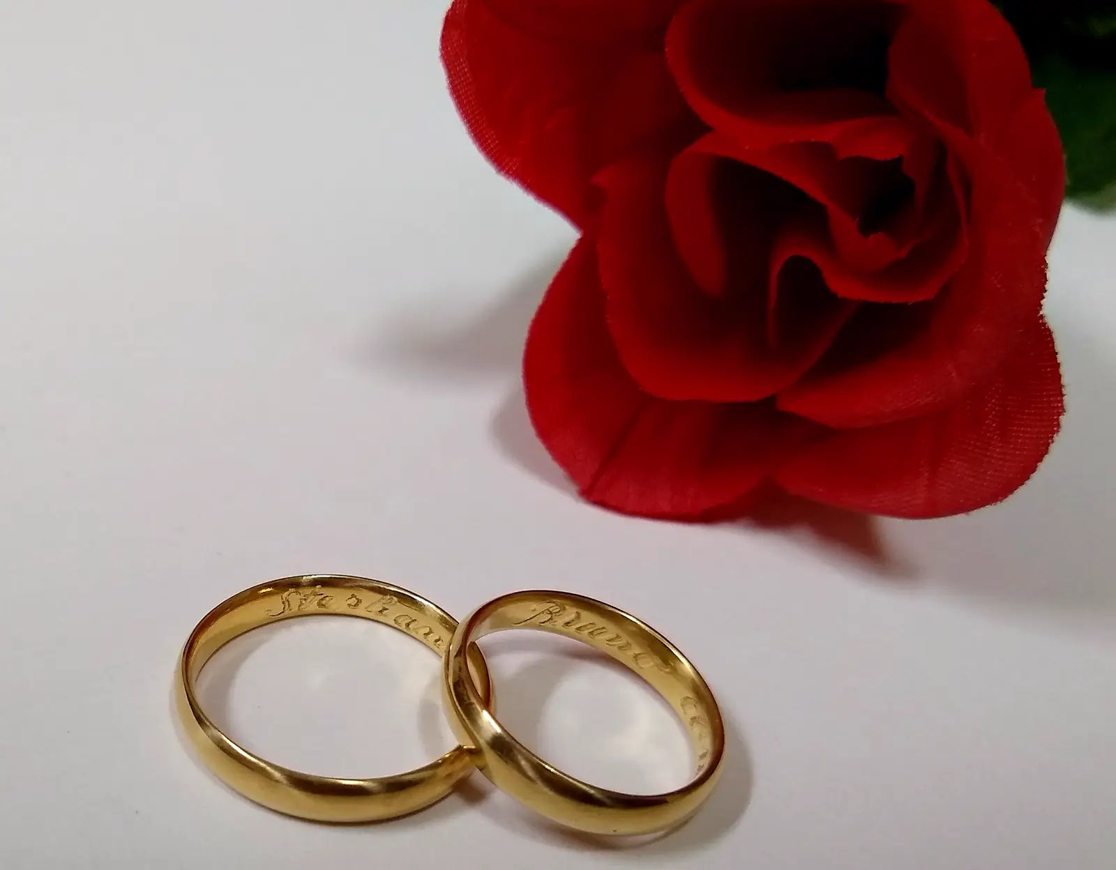 Dos alianzas de boda doradas, una apoyada sobre la otra, en primer plano