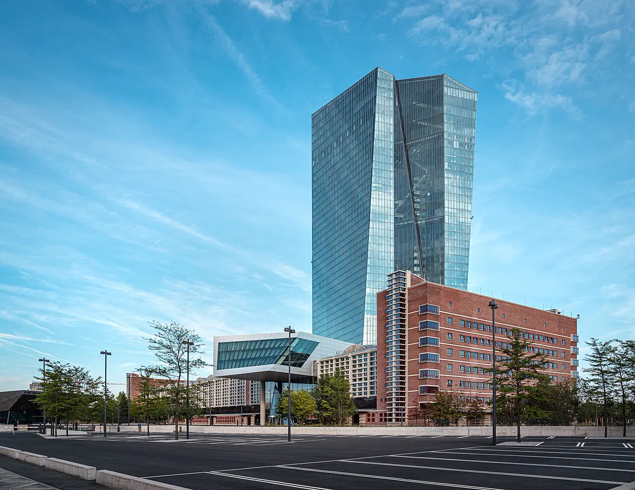 La torre acristalada del Banco Central Europeo en Fráncfort, con el edificio de ladrillo del antiguo mercado mayorista a sus pies y un aparcamiento vacío en primer plano