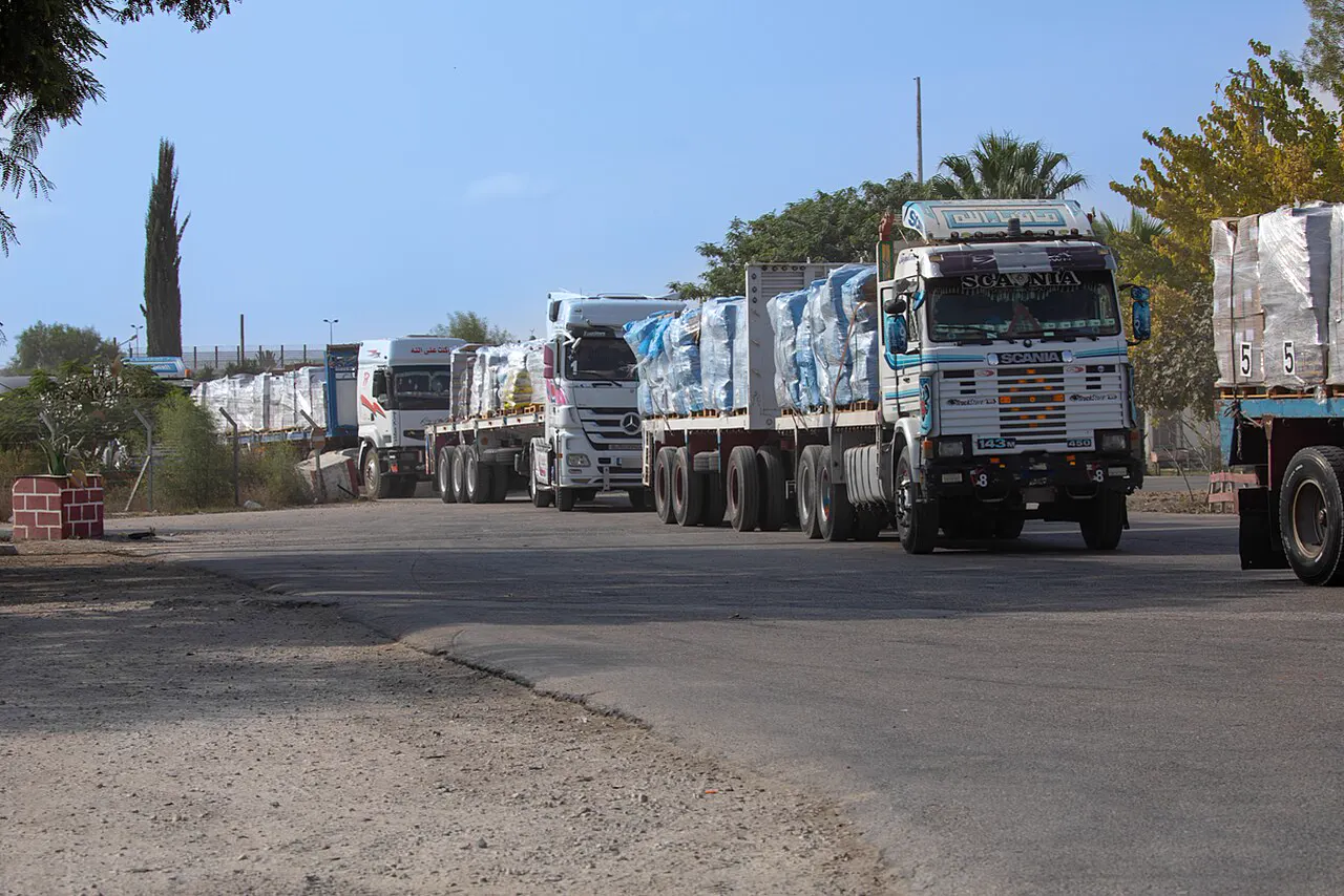Fila de camiones cargados con palés de ayuda humanitaria en una explanada del paso fronterizo de Kerem Shalom