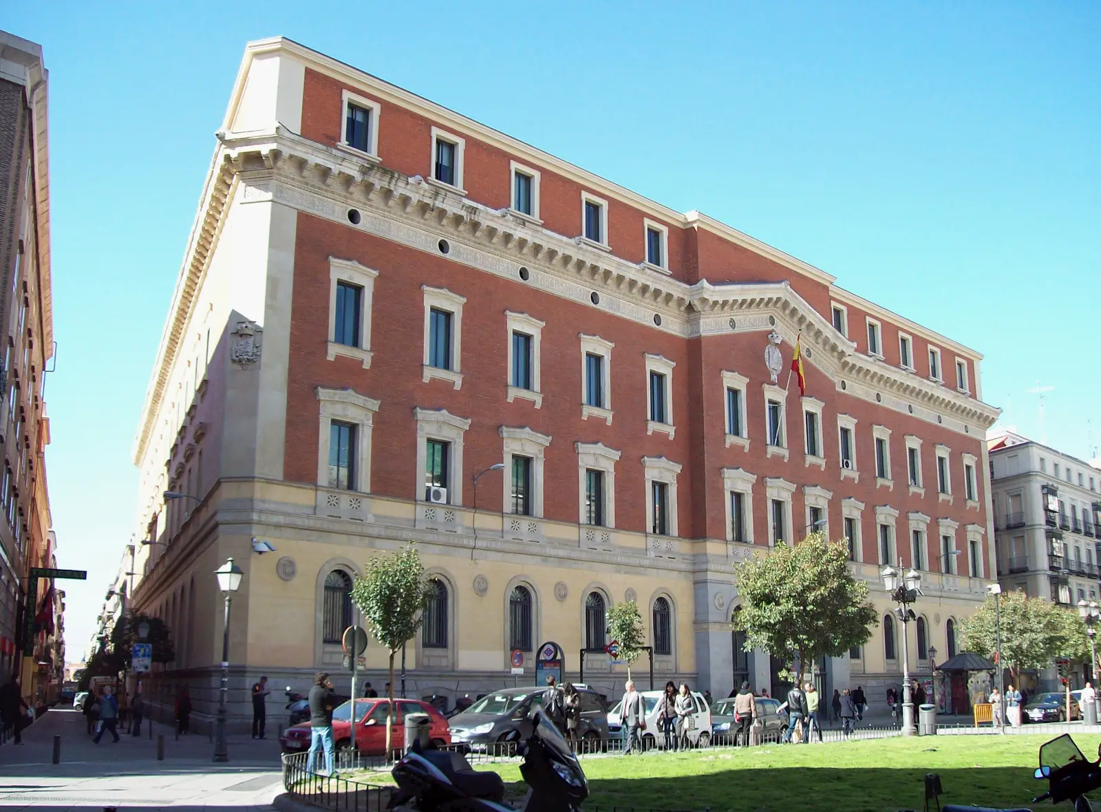 Fachada de piedra del edificio del Tribunal de Cuentas en la calle Fuencarral de Madrid, con arcos en la planta baja y balcones sobre ellos.