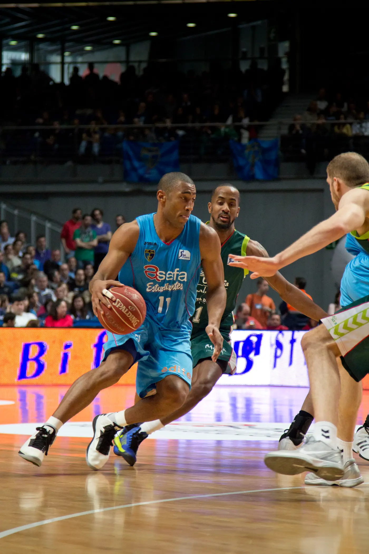 Jayson Granger, con la camiseta azul del Asefa Estudiantes, avanza botando el balón ante dos defensores del Unicaja en un partido de la Liga ACB