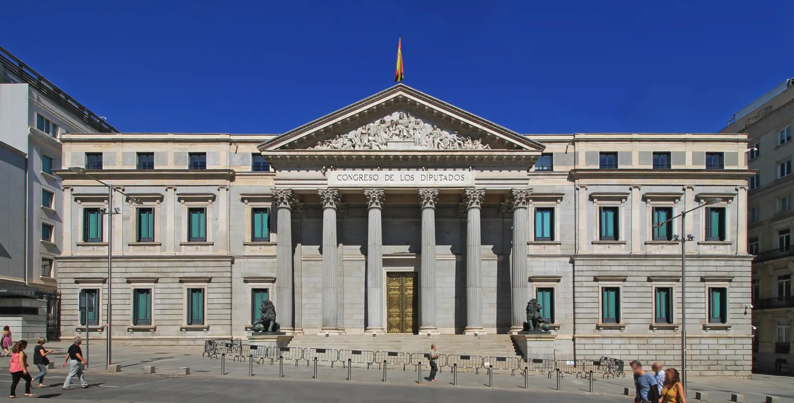 Fachada principal del Palacio de las Cortes, con su pórtico de ocho columnas corintias, el frontón esculpido, la inscripción «Congreso de los Diputados» y los dos leones de bronce a los lados de la escalinata.