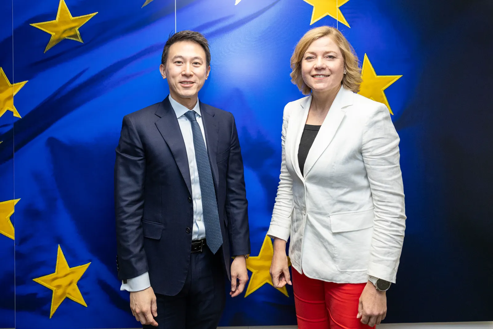 Shou Zi Chew, consejero delegado de TikTok, y Henna Virkkunen, vicepresidenta ejecutiva de la Comisión Europea, posan ante una bandera de la Unión Europea