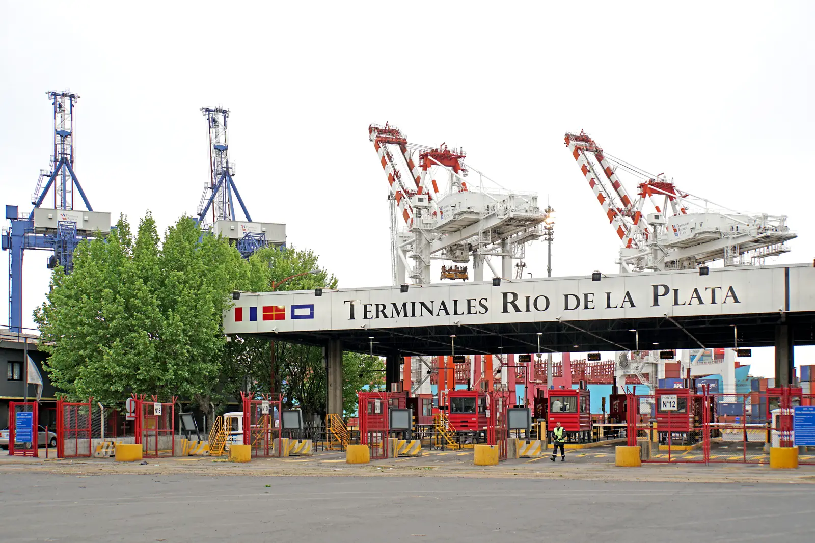 Acceso a la terminal de contenedores Terminales Río de la Plata, en el puerto de Buenos Aires, con grúas pórtico y contenedores apilados al fondo