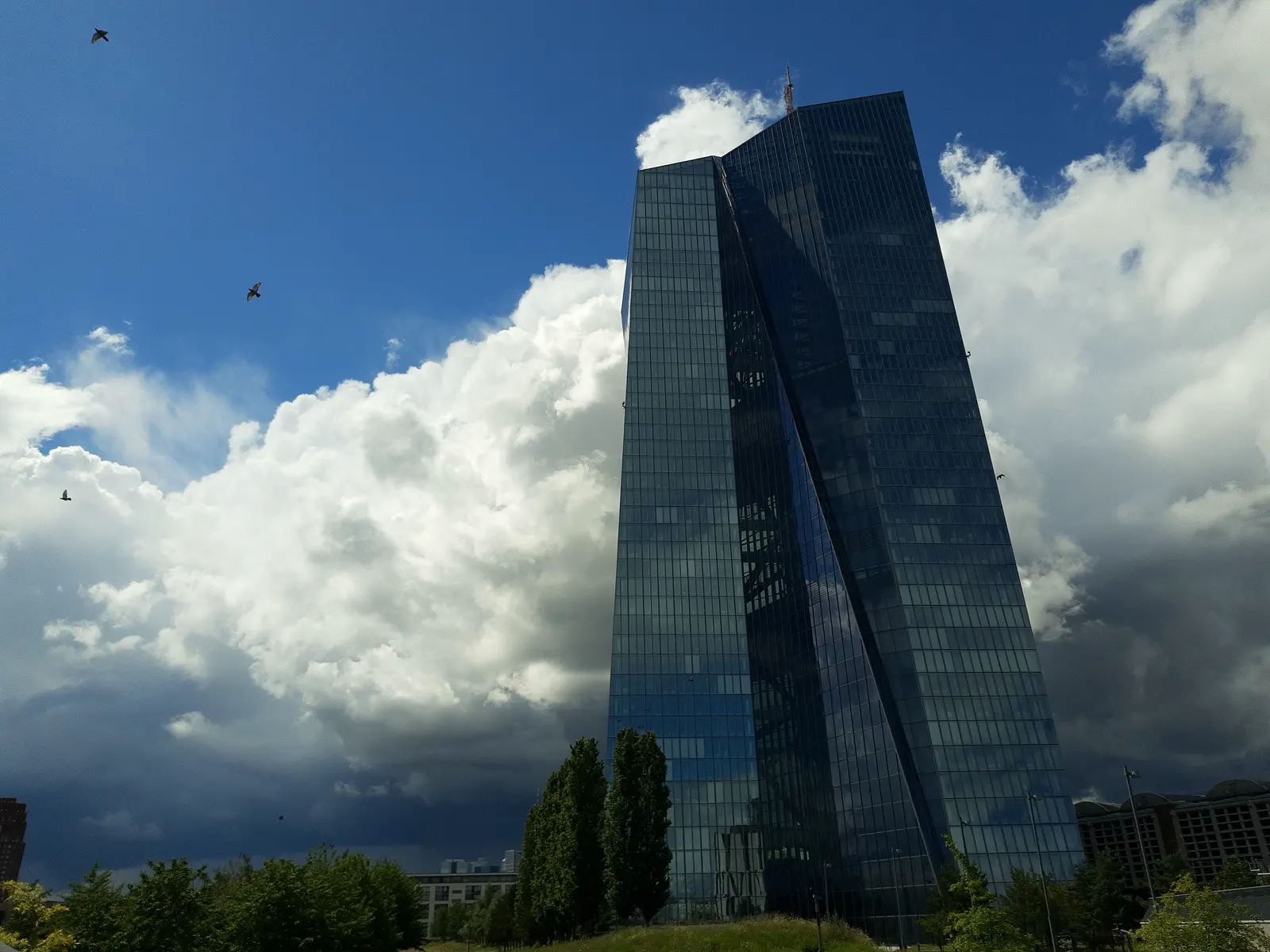 La torre acristalada de la sede del Banco Central Europeo en Fráncfort vista desde el este, recortada contra un cielo de nubes de tormenta