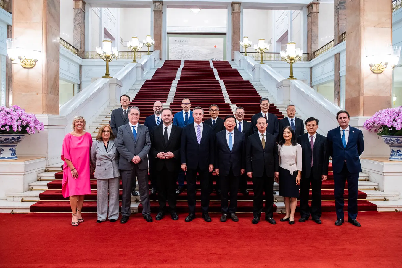 Foto de familia de quince personas trajeadas, eurodiputados y cargos chinos, sobre una alfombra roja al pie de la escalinata de mármol del Gran Palacio del Pueblo, en Pekín.