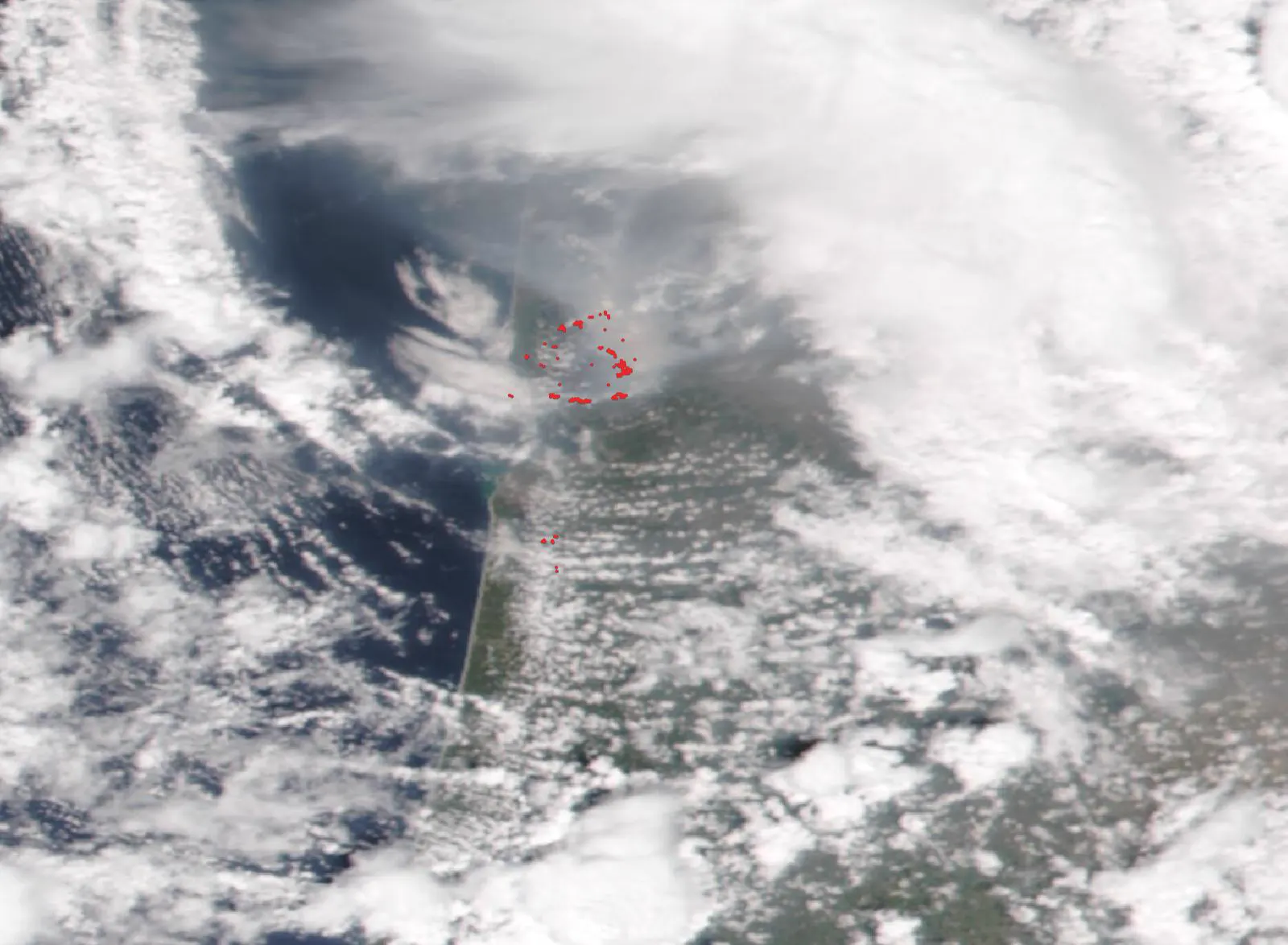 Imagen de satélite del suroeste de Francia el 25 de julio de 2026: sobre la costa atlántica y la bahía de Arcachón se ve un arco de puntos rojos que marcan los focos de calor detectados, un segundo grupo más pequeño al sur y una gran mancha parda de humo que se extiende hacia el interior entre las nubes.