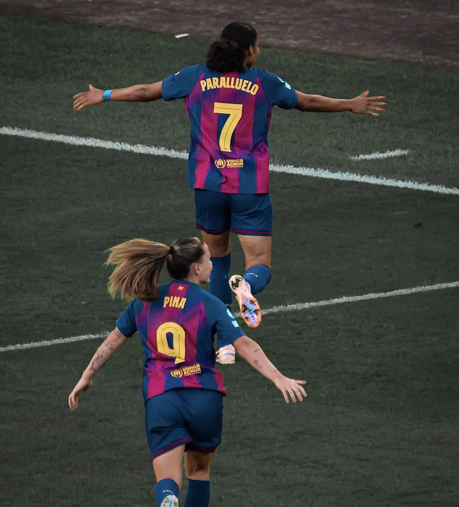 Salma Paralluelo, de espaldas, con la camiseta azulgrana del FC Barcelona y el dorsal 7 y su apellido a la espalda, corre con los brazos abiertos sobre el césped; detrás va hacia ella Claudia Pina, con el dorsal 9