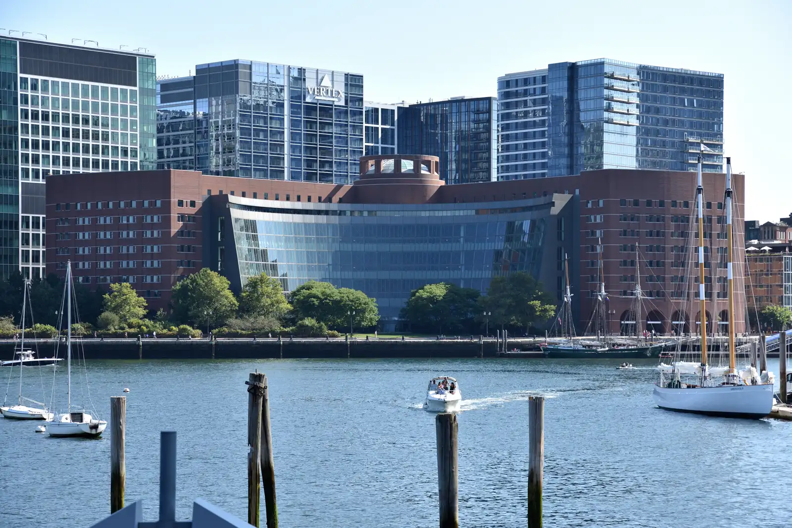Edificio del juzgado federal John Joseph Moakley en Boston, de ladrillo rojizo y gran fachada acristalada curva sobre el muelle de Fan Pier, con el puerto en primer término.