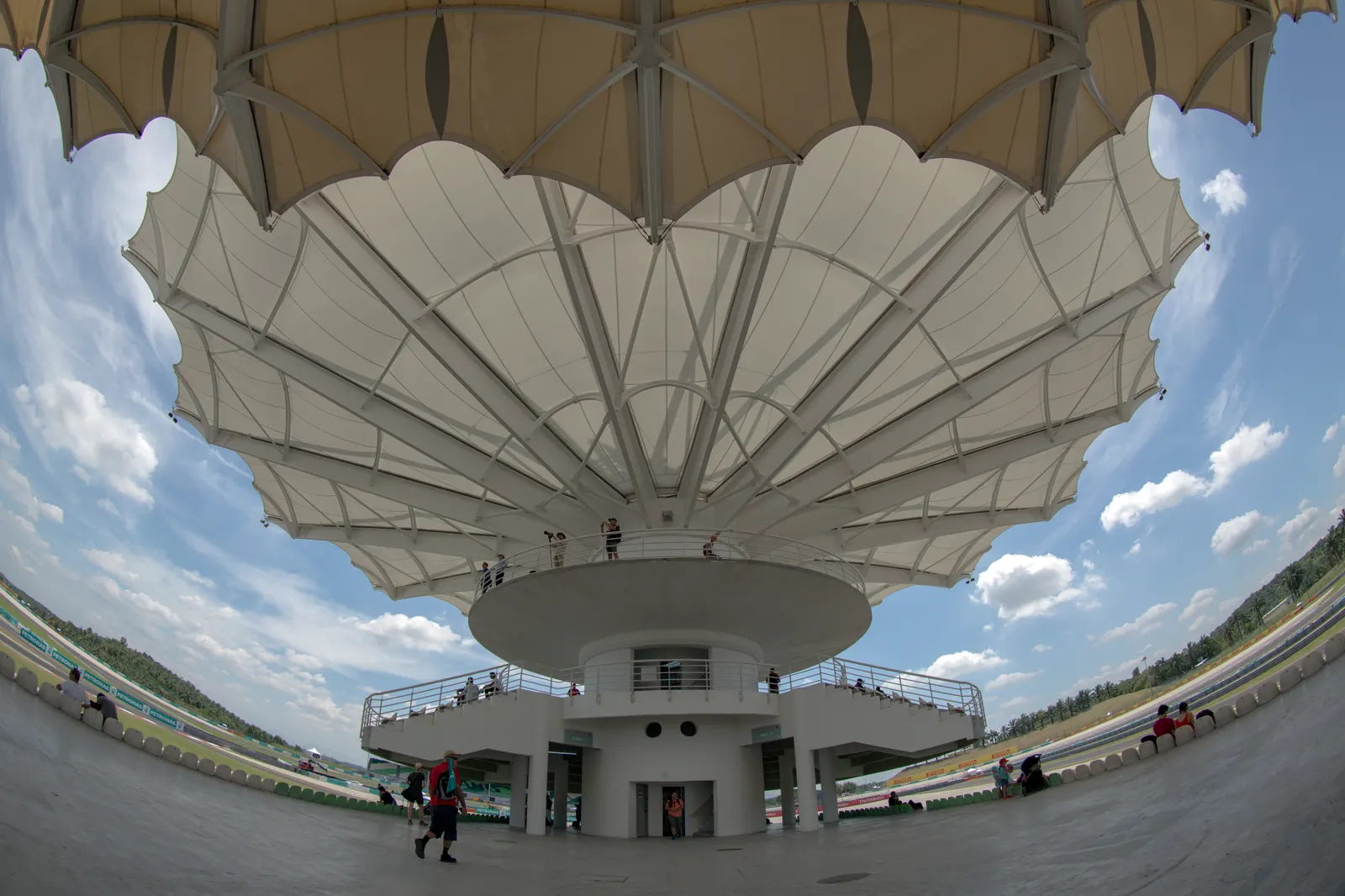 Torre-tribuna del Circuito Internacional de Sepang, con su cubierta blanca en forma de pétalos, espectadores asomados a las plataformas y el trazado al fondo