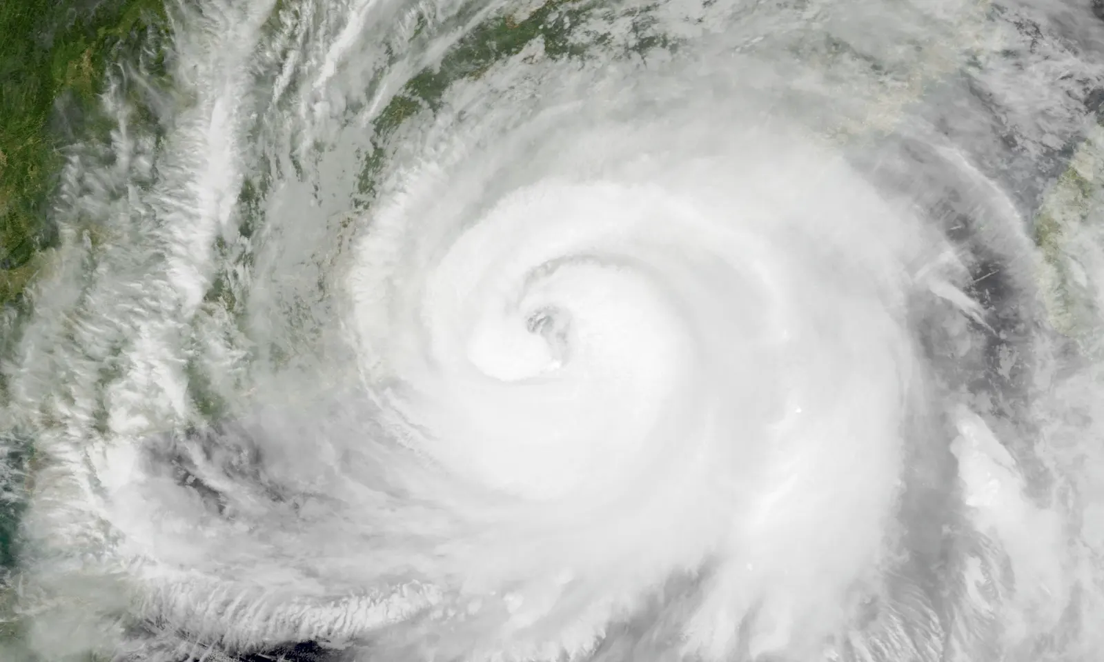 Imagen de satélite del tifón Noul sobre el mar de China Meridional: una espiral de nubes blancas con un ojo bien definido en el centro, con la costa verde del sur de China visible en el borde izquierdo y superior de la imagen.