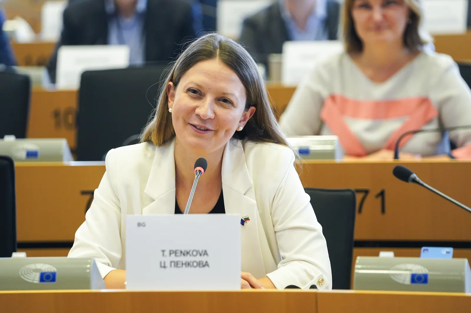 La eurodiputada Tsvetelina Penkova, sentada ante un micrófono en una sala de comisión del Parlamento Europeo, con un cartel con su nombre delante.
