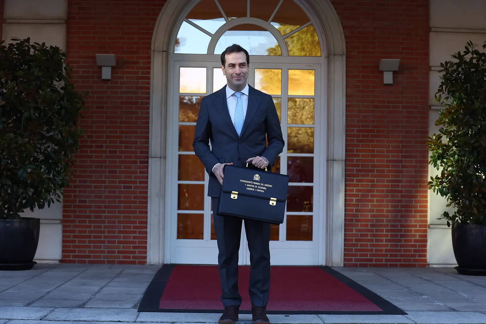 Carlos Cuerpo, vicepresidente primero y ministro de Economía, Comercio y Empresa, posa con su cartera ministerial en la escalinata del edificio del Consejo de Ministros.