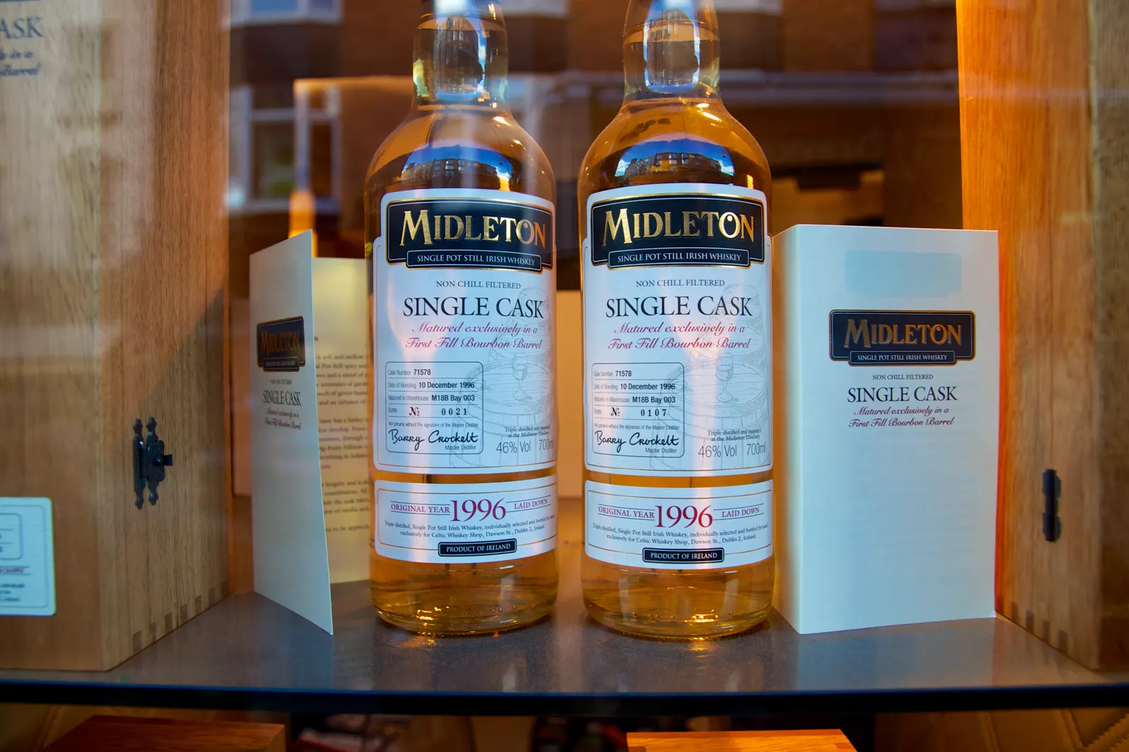 Dos botellas de whisky irlandés Midleton Single Cask en el escaparate iluminado de una tienda, con la etiqueta «Product of Ireland»